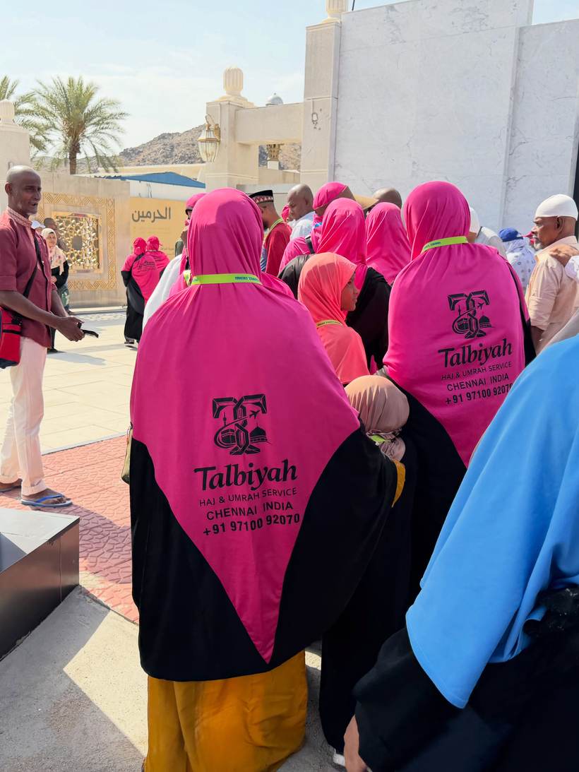 Pilgrims in the group’s pink Talbiyah shoulder scarves walking together in Madinah.